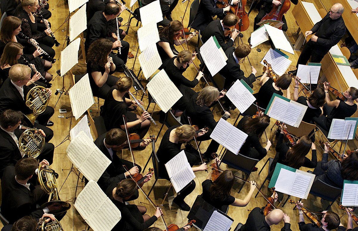 Dirigent Peter Bauer und einige MusikerInnen des Universitätsorchesters